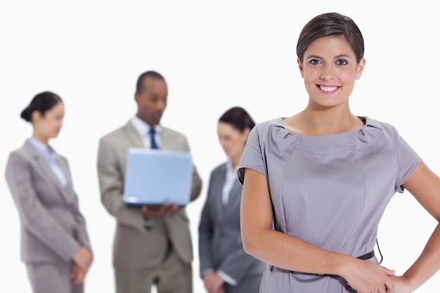 Vrouw met handen op haar heupen met commercieel team op de achtergrond