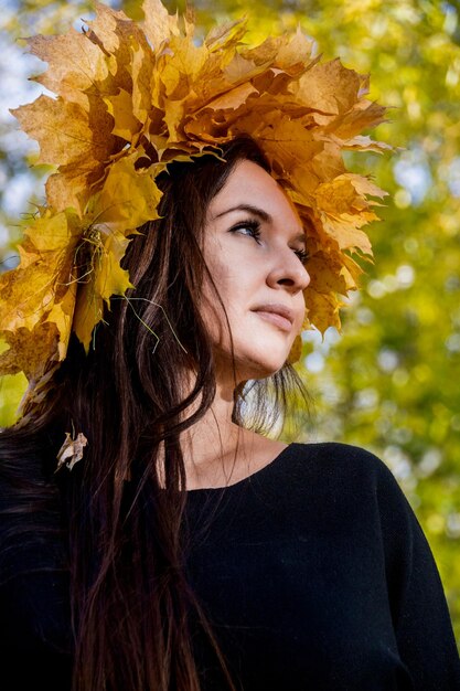 Vrouw met herfstbladeren op haar