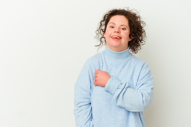 Vrouw met het syndroom van Down geïsoleerd glimlachend en opzij wijzend, iets op lege ruimte laten zien.