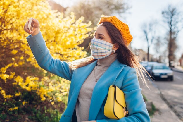 Vrouw met hoed die masker in openlucht draagt