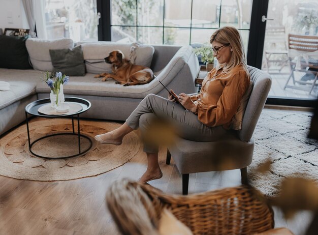 Foto vrouw met hond die thuis zit.