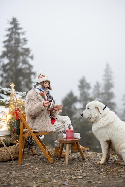 Vrouw met hond in de bergen op wintervakantie