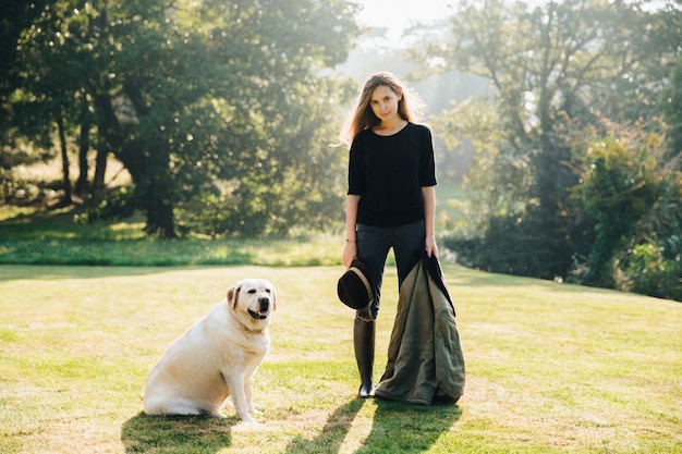 Vrouw met hond op zonnig gazon