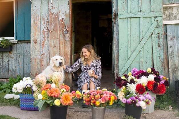 Vrouw met hond tussen bloemenmandjes