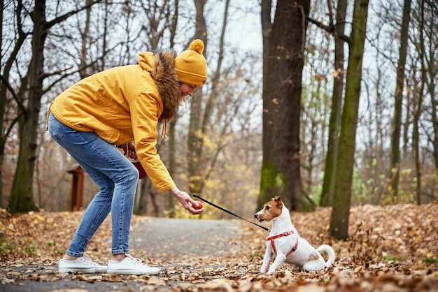 Vrouw met hond wandeling in herfst park