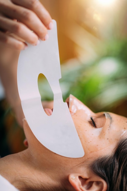 Vrouw met huidverzorging gezichtsmasker in schoonheidssalon