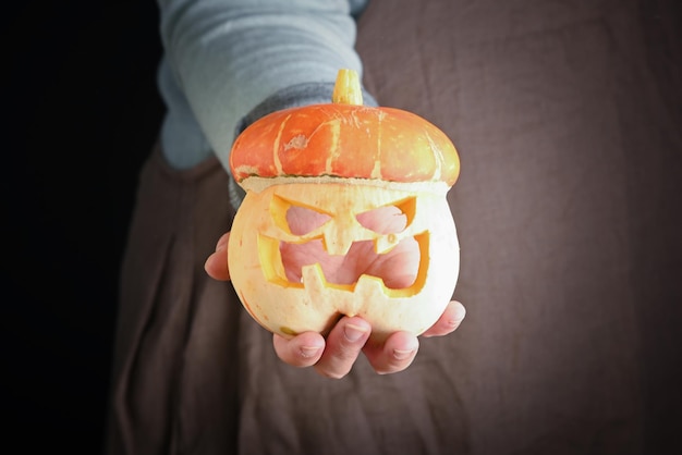 Vrouw met in de hand verse pompoen close-up Carving A Pumpkin For Halloween