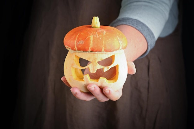 Vrouw met in de hand verse pompoen close-up Carving A Pumpkin For Halloween