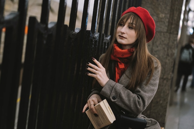 vrouw met jasbaret en sjaal die alleen op het metrostation van Sint-Petersburg zit en een boek leest