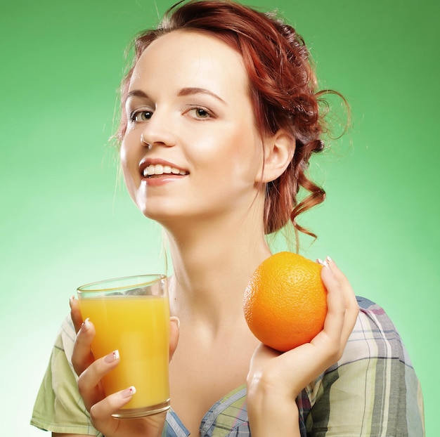 Vrouw met jus d'orange over groene background