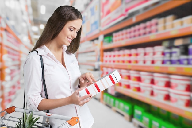 Vrouw met kar winkelen in supermarkt