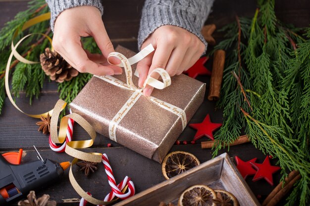 Vrouw met kerstcadeautjes gelegd op een houten tafel achtergrond.