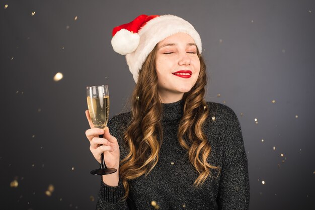 Vrouw met kerstmuts met een glas champagne