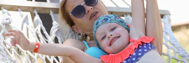 Vrouw met kind schommel op hangmat in street