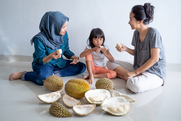 Vrouw met kinderen die durian fruit eten