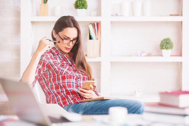 Vrouw met Kladblok met smartphone