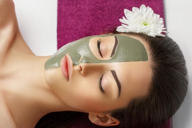 Vrouw met klei gezichtsmasker in beauty spa Skincare Beauty Concept