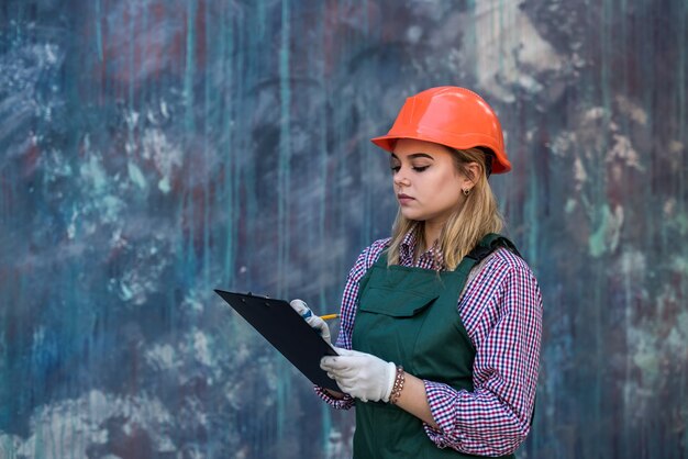 Vrouw met klembord in uniform reparatie in haar huis. concept van renovatie