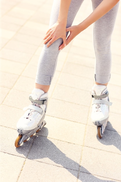 vrouw met knieprobleem tijdens rolschaatsen roller