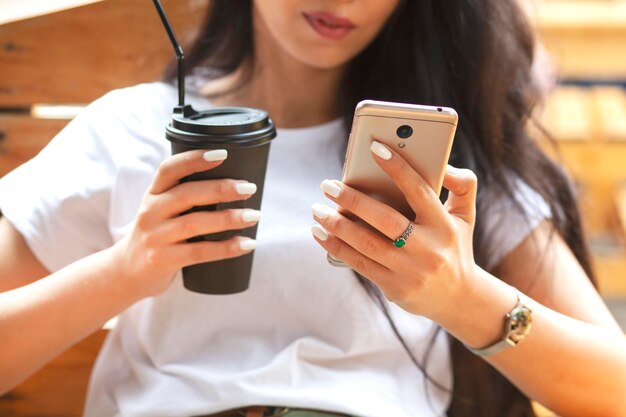 Vrouw met koffie en telefoon in café