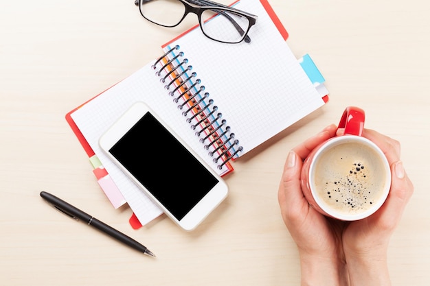 Vrouw met koffiekopje op bureau