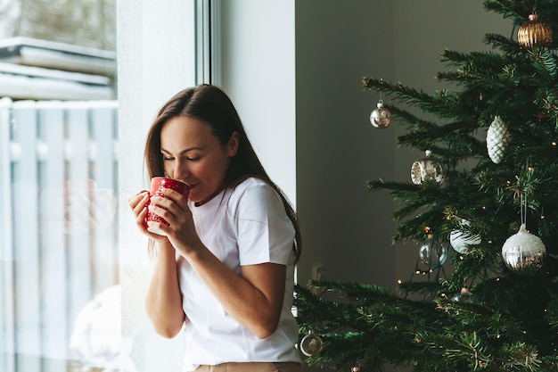 Vrouw met kop bij kerstboom