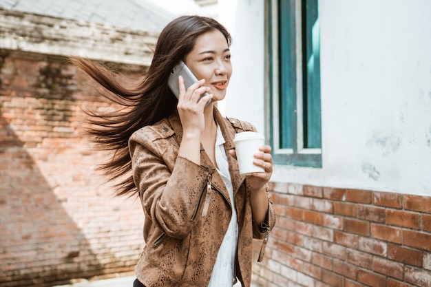 Vrouw met kop en koffie die lopen roepen