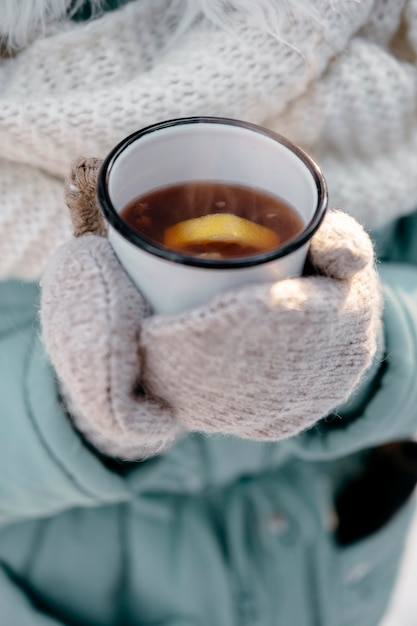 Vrouw met kopje thee buiten in de winter