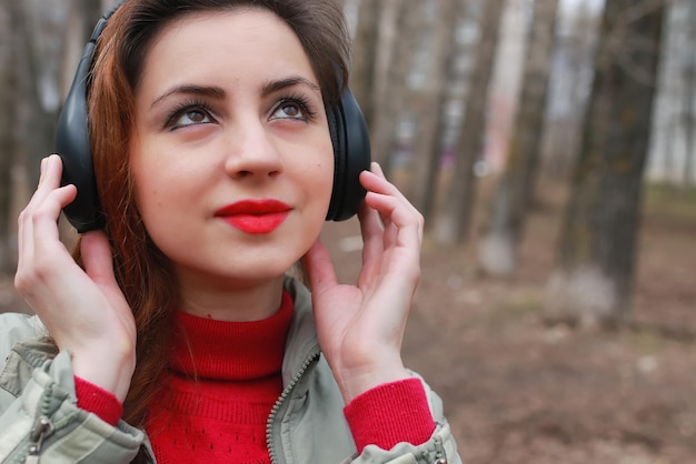 Vrouw met koptelefoon in park herfst