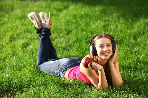 Vrouw met koptelefoon luisteren muziek op het gras