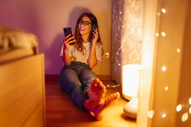 Vrouw met koptelefoon voor het slapen gaan luistert online naar ontspannende muziek Op afstand werken internetconcept