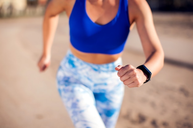 Vrouw met kort blond haar buiten lopen. Detailopname. Mensen, fitness en gezondheidszorg concept