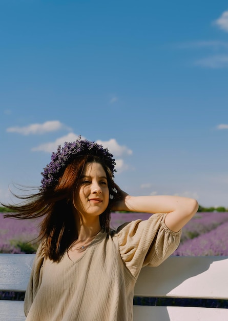 Vrouw met krans van bloemen in lavendelveld