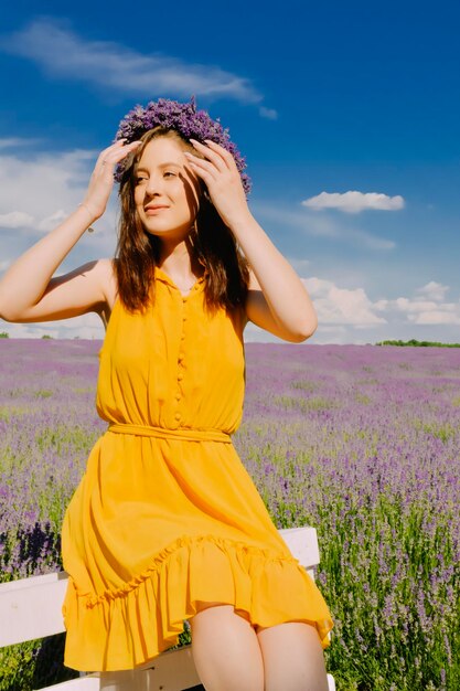 Vrouw met krans van bloemen in lavendelveld