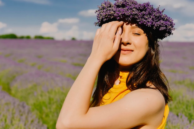 Vrouw met krans van bloemen in lavendelveld