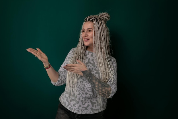 Vrouw met lang blond haar voor de groene muur.