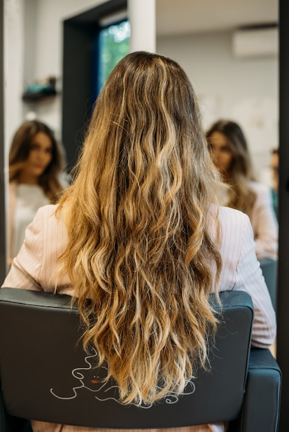 Vrouw met lange haarzitting in een kapper