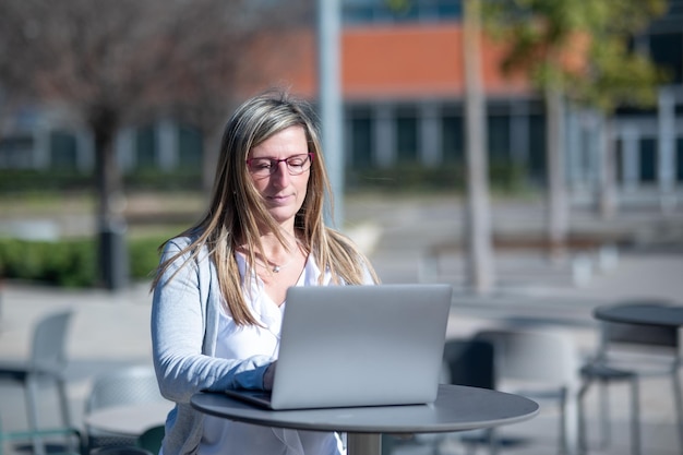 Vrouw met laptop buiten in een kantoorruimte