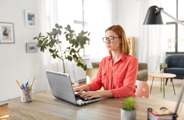 Vrouw met laptop die thuis werkt.