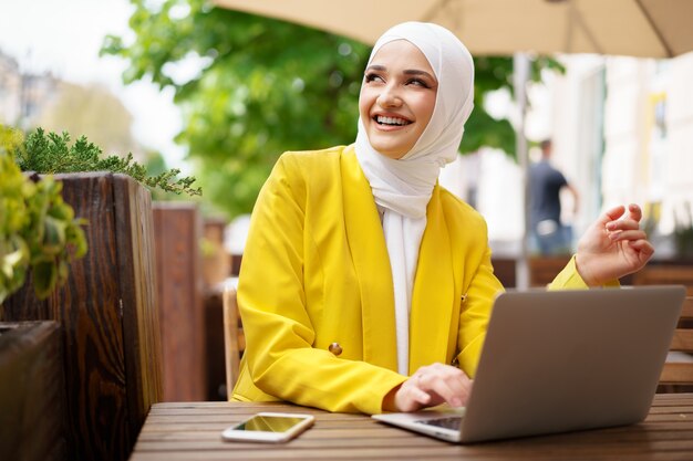 vrouw met laptop in café