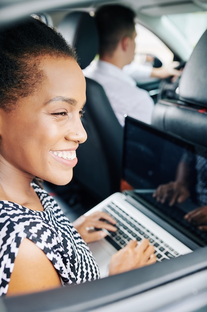 Vrouw met laptop in de auto