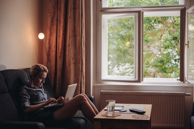 Vrouw met laptop in de woonkamer