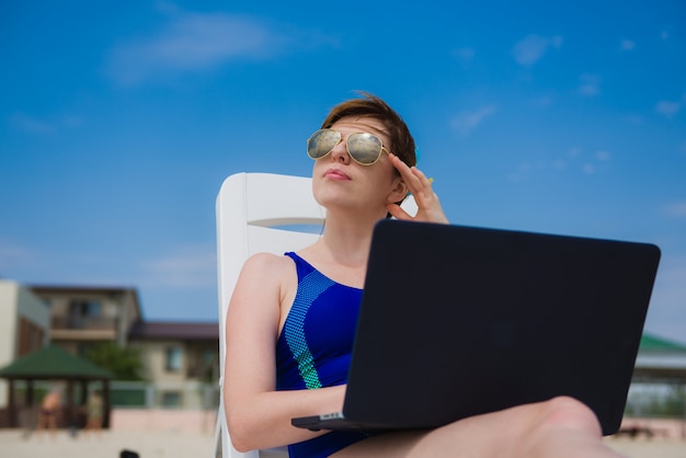 Vrouw met laptop op het strand