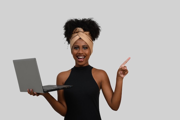 vrouw met laptop typend op toetsenbord kijkend naar de camera, wijzend naar de rechterkant van het beeld