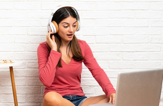 Vrouw met laptop zittend op de vloer