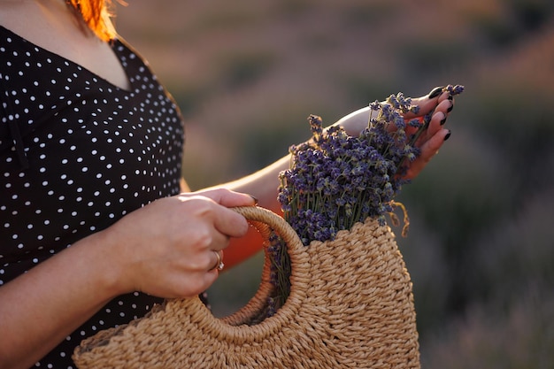 Vrouw met lavendelbloemen in een strozak