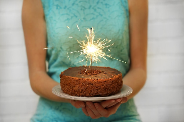 Vrouw met lekkere cake met sterretje op grijze muur achtergrond