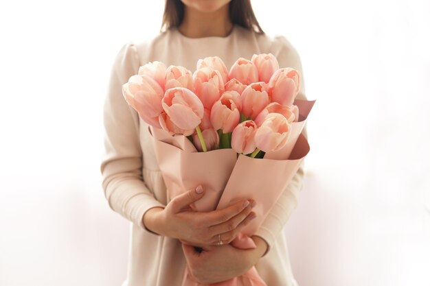 Vrouw met lentebloemboeket. Blij verrast model vrouw ruikende bloemen. Moederdag. Vrouwendag. Lente bloem samenstelling.