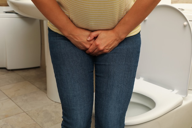 Foto vrouw met lies in de badkamer in de buurt van de wc-pot