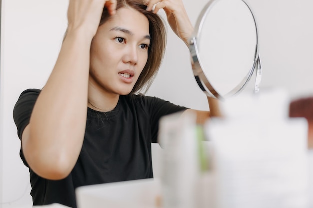 Vrouw met make-up voor de spiegel in een witte heldere kamer